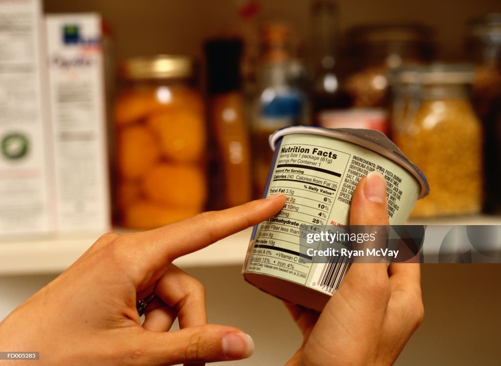 Person Reading Nutrition Label on Packaged Food