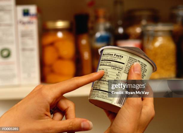 person reading nutrition label on packaged food - etiqueta nutricional imagens e fotografias de stock