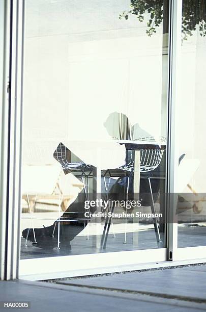 reflection of businessman reading newspaper in glass door - stehen stock pictures, royalty-free photos & images