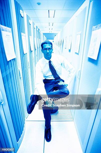 technician sitting on stool in server room, portrait - stehen stock pictures, royalty-free photos & images