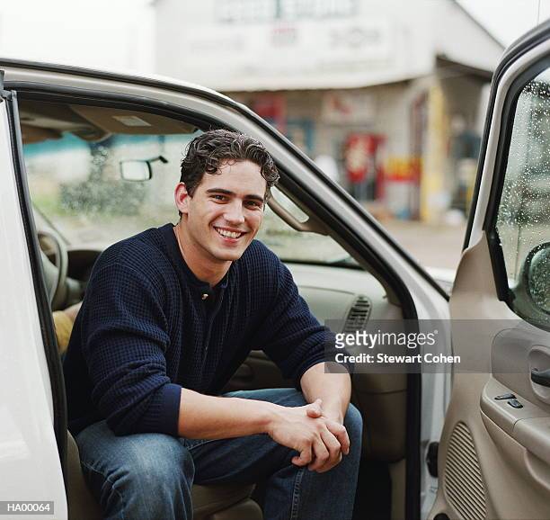 young man in car, smiling, portrait - stewart stock-fotos und bilder