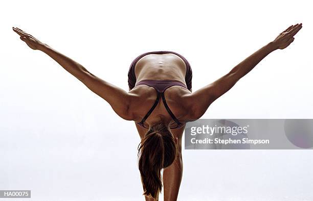 young woman bending over with arms outstretched - stehen stock pictures, royalty-free photos & images