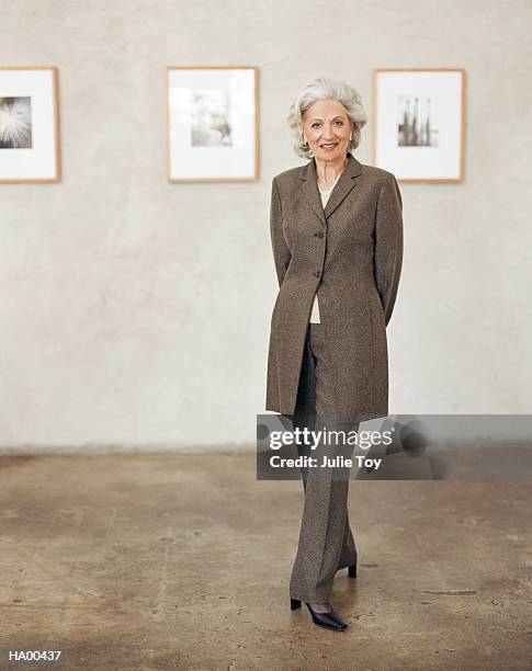 mature woman in art gallery - stéréotype de la classe moyenne photos et images de collection