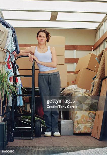 young woman standing in back of moving truck, portrait - garcia stockfoto's en -beelden