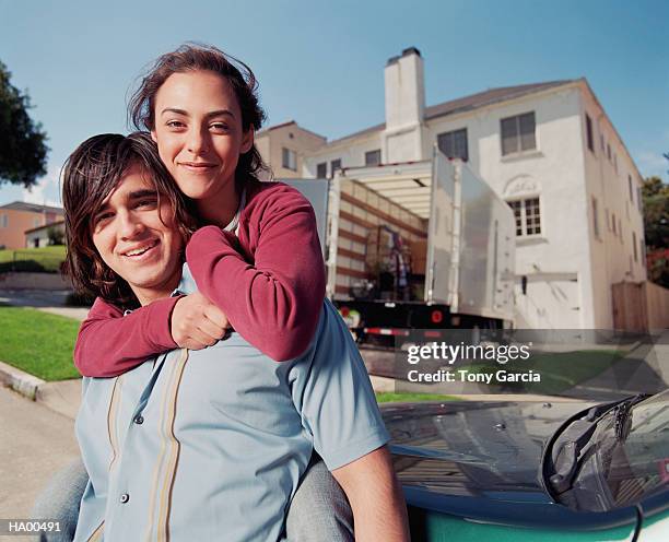 young couple outside of house, moving van in driveway - garcia stockfoto's en -beelden