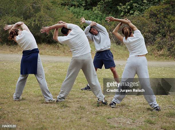 man leading group in stretching exercise - jurgen stock pictures, royalty-free photos & images
