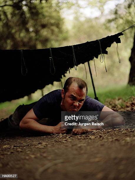 man crawling on ground under obstacle net - jurgen stock pictures, royalty-free photos & images