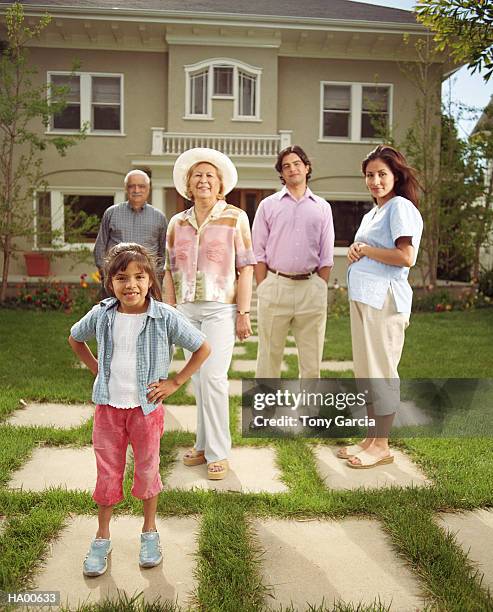 girl (4-6) in front yard with family, portrait - garcia stockfoto's en -beelden