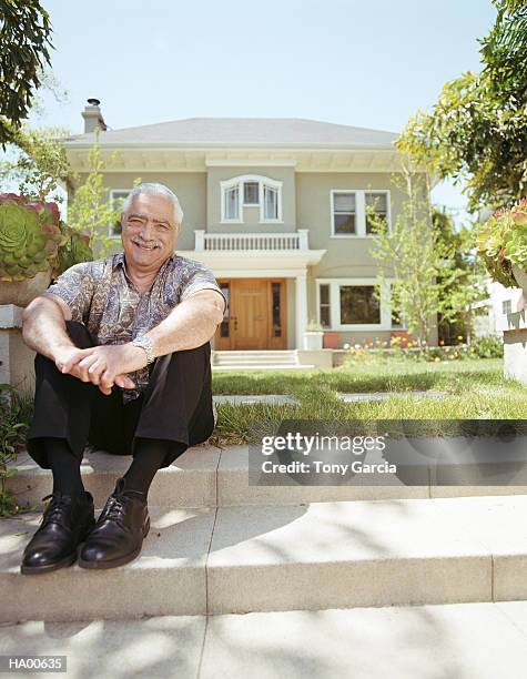 mature man sitting on stairs in front of house, portrait - garcia stockfoto's en -beelden