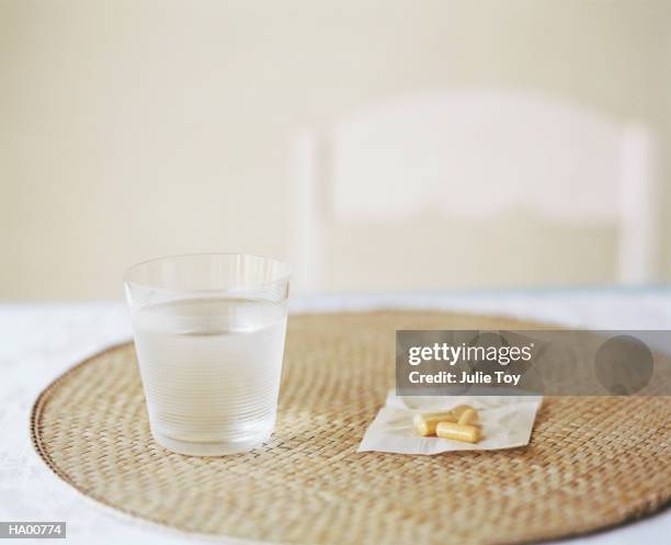 glass of water and pills on placemat - place mat stock pictures, royalty-free photos & images