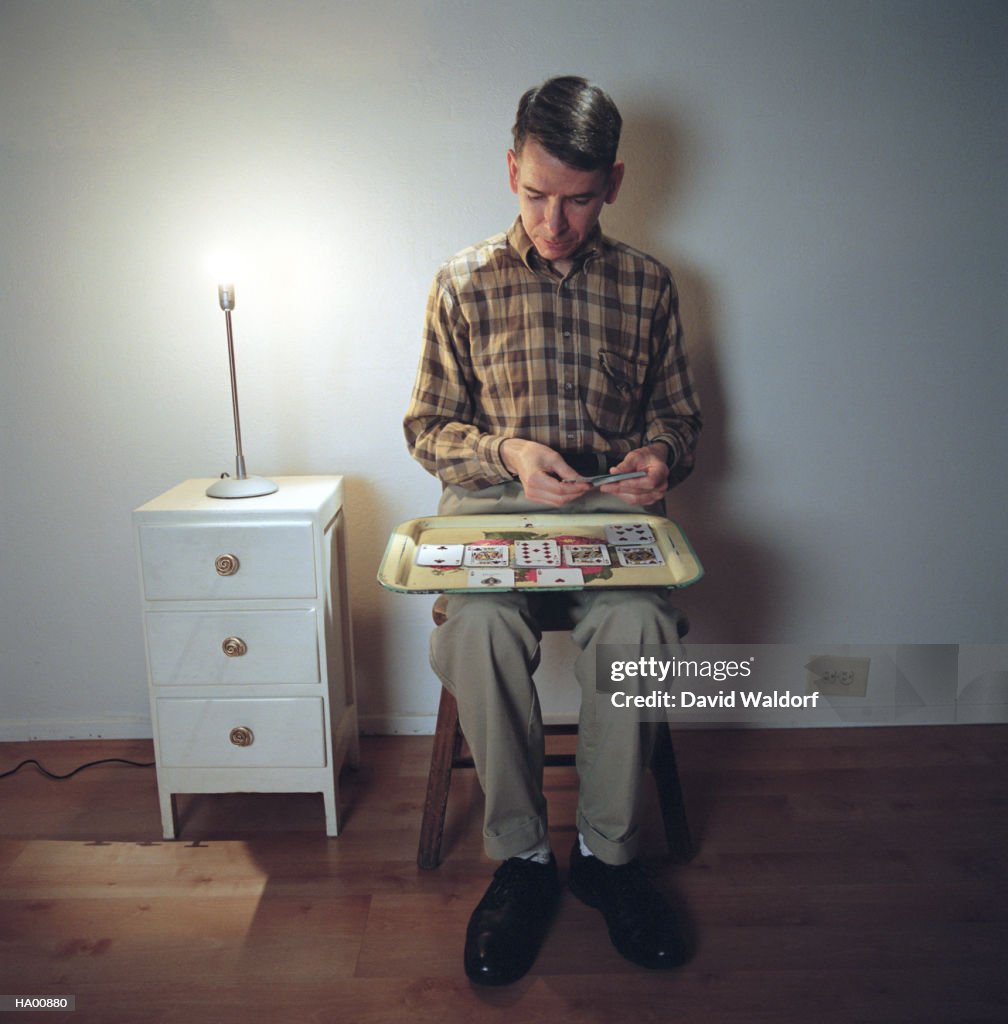 Mature man playing solitaire on tray