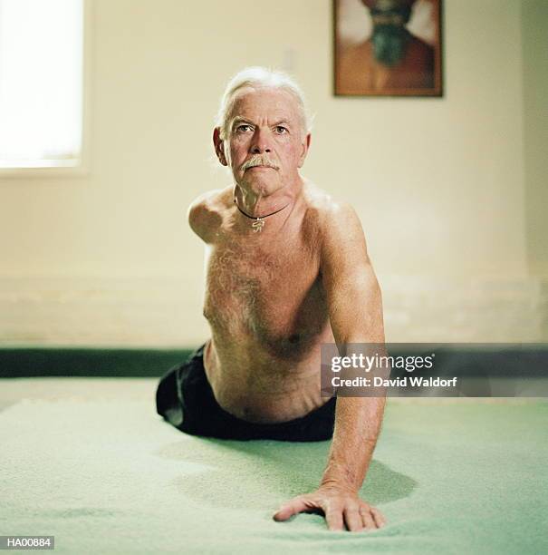 mature man doing yoga exercises on floor - waldorf stock pictures, royalty-free photos & images