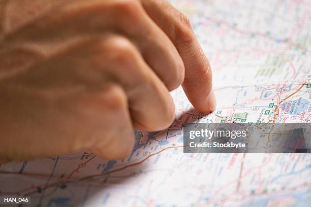 man's hand pointing to spot on map - world at your fingertips stockfoto's en -beelden