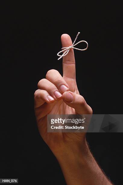 hand with string tied around index finger - string - fotografias e filmes do acervo