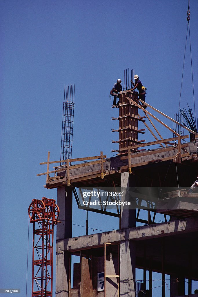 Two men working on building framework