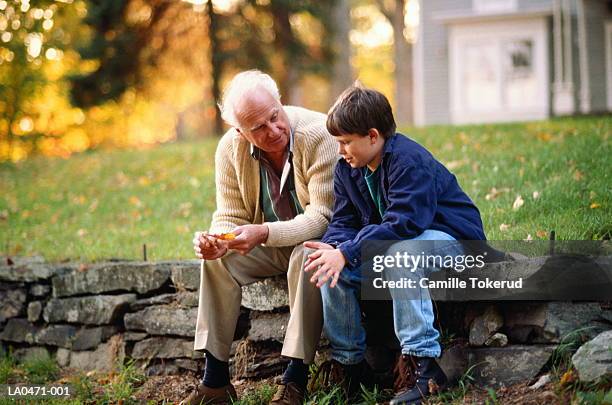 пожилой человек рассказывает внуку о старых фотографиях