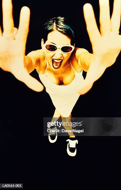 young woman wearing sunglasses, arms outstretched, elevated view - gel effect lighting stock pictures, royalty-free photos & images