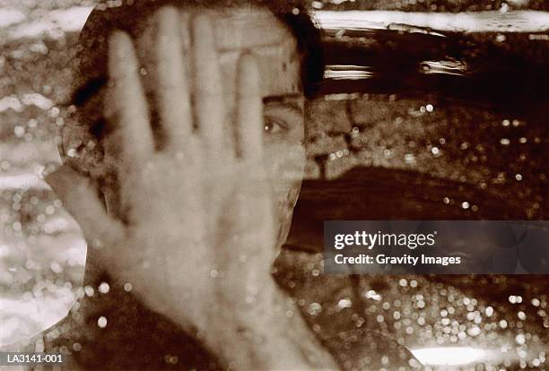 woman wiping water off window, hand in front of face (toned b&w) - rain face stock pictures, royalty-free photos & images
