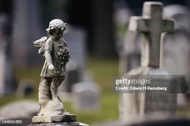 gravestones and statues in cemetery, close-up - grafsteen stockfoto's en -beelden
