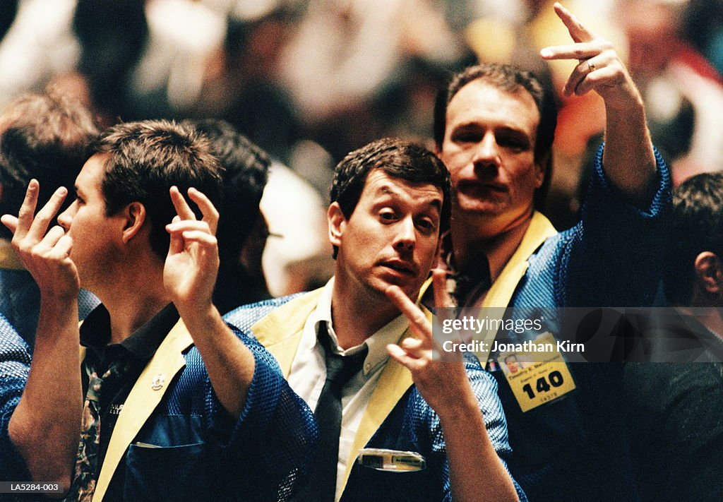 Traders gesturing on stock trading floor, USA