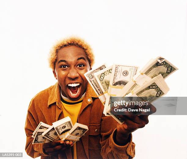 young man holding bundles of us dollars, laughing, portrait - 2005 20 stock pictures, royalty-free photos & images