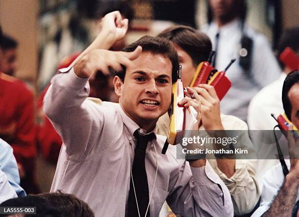 trader using mobile phone, shouting and gesticulating on trading floor - bear market stock pictures, royalty-free photos & images