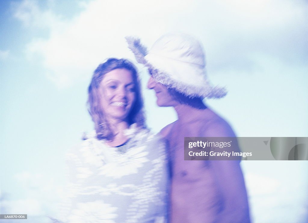 Couple smiling, man wearing summer hat