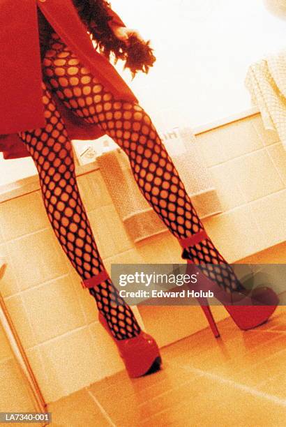young woman wearing fishnet tights, low section - prostitutie stockfoto's en -beelden