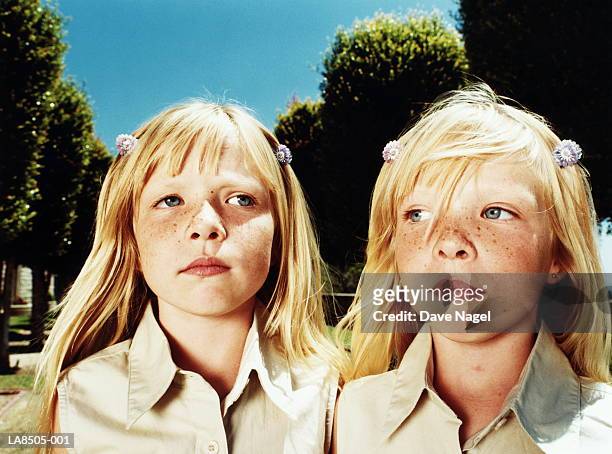 twin girls (6-8), close-up - ripetizione foto e immagini stock