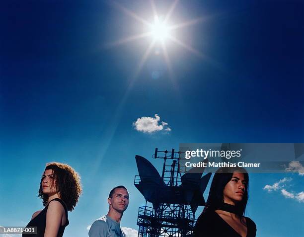 three people by microwave transmission tower - male with group of females stock pictures, royalty-free photos & images