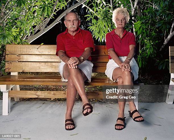 mature couple in matching clothes on garden bench, portrait - mesma roupa imagens e fotografias de stock