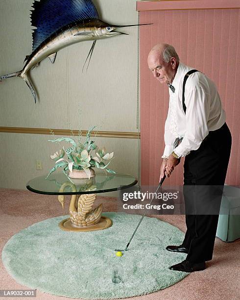 mature man putting golf ball indoors - trophy wall stock pictures, royalty-free photos & images