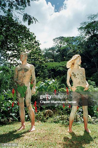 naked man and woman covered in mud, outdoors - adam and eve stockfoto's en -beelden