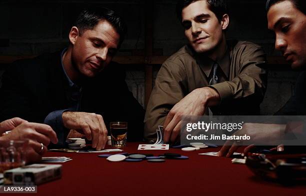 group of men playing poker game - poker photos et images de collection