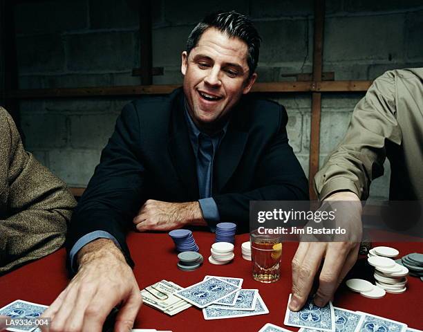 man playing poker game, smiling - poker card game stockfoto's en -beelden