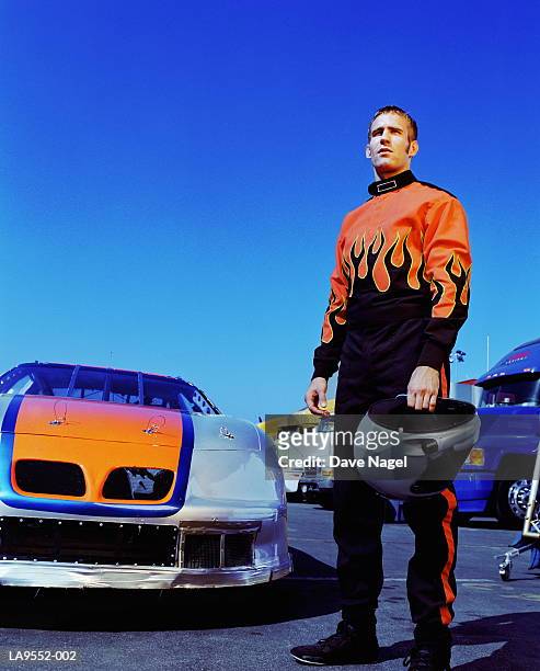 racing car driver standing by racing car - race car driver portrait stock pictures, royalty-free photos & images