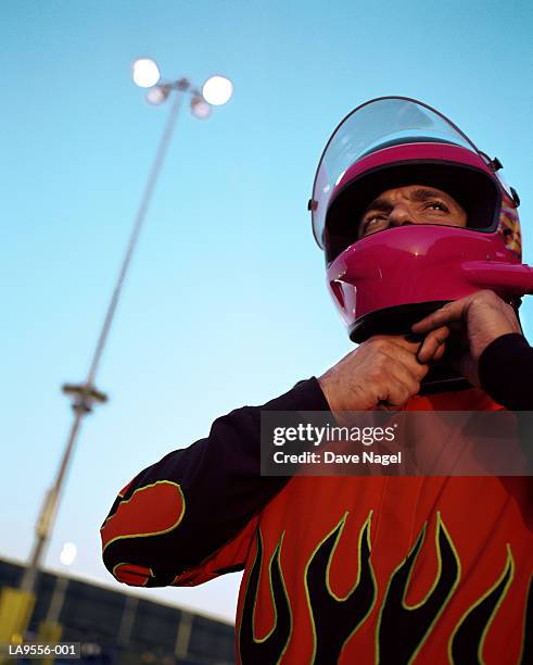 male racing car driver suiting up for race - get dressed male stock-fotos und bilder