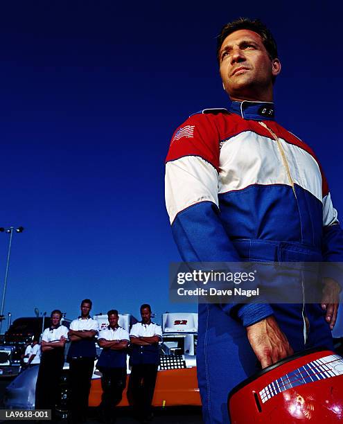 racing car driver, pit crew in background - racing car driver stock pictures, royalty-free photos & images