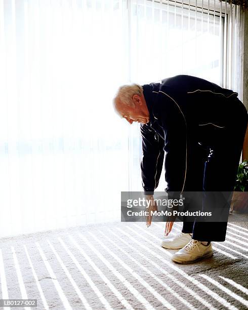 mature man touching toes - touching toes stock pictures, royalty-free photos & images