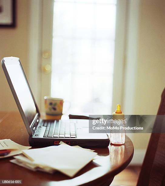 baby bottle next to laptop on table - working mother stock pictures, royalty-free photos & images