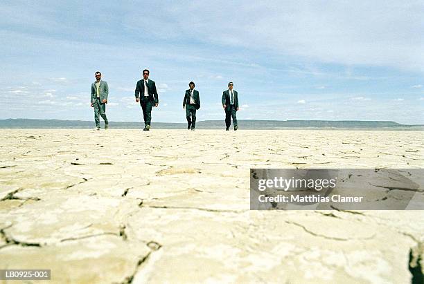 four businessmen walking in desert - american gangsters stock pictures, royalty-free photos & images