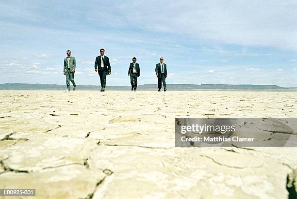 four businessmen walking in desert - gangster stock pictures, royalty-free photos & images