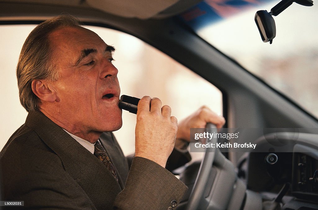 Businessman Shaving and Driving a Car