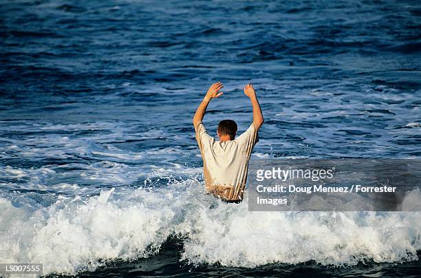 man in tee shirt in ocean - tee shirt stockfoto's en -beelden