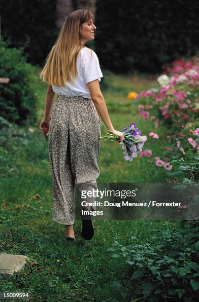 woman walking in garden - iris family stock pictures, royalty-free photos & images