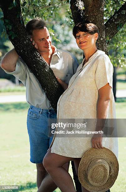 couple by tree - roupa de grávida imagens e fotografias de stock