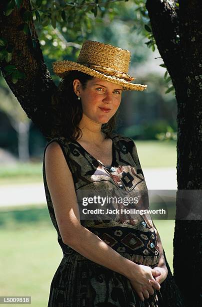 woman wearing straw hat - roupa de grávida imagens e fotografias de stock