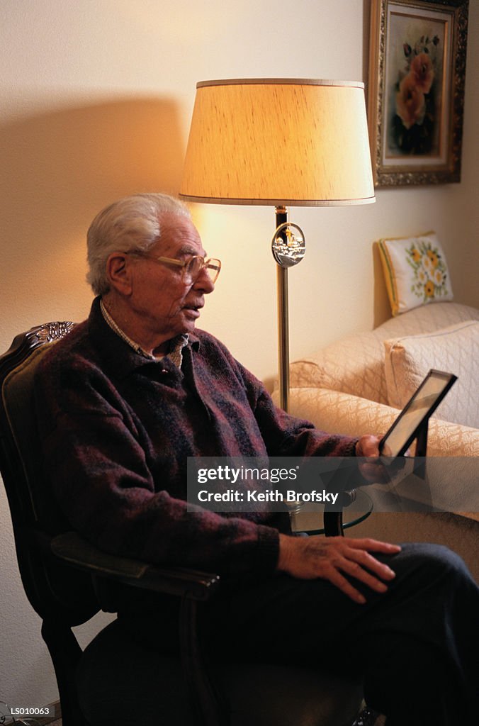 Elderly Man Looking at Photograph