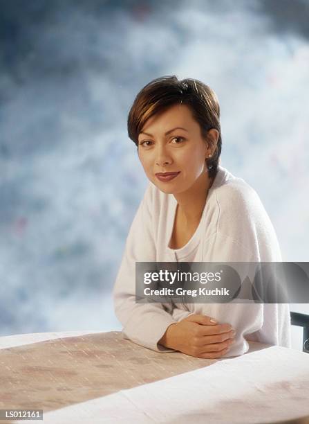 woman sitting at a table - greg stock pictures, royalty-free photos & images