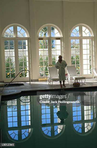 woman standing by swimming pool - balneotherapy stock pictures, royalty-free photos & images